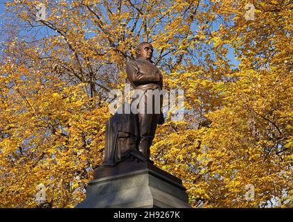 New York, NY - 15. November 2021: Statue des berühmten Advocaten Daniel Webster im Central Park, mit brillantem Herbstlaub Stockfoto