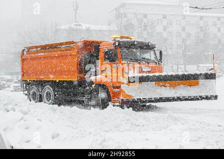 Ein großer orangefarbener Schneepflug steht auf der Straße, bevor Schnee entfernt wird. Sonderausrüstung für Schneeräumungszyklon. Stockfoto