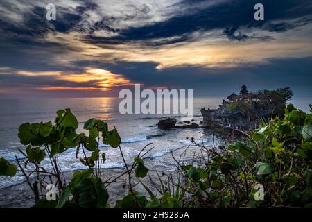 Wolkiger Himmel über dem Tana Lot Tempel und dem Meer in Bali, Indonesien bei Sonnenuntergang Stockfoto