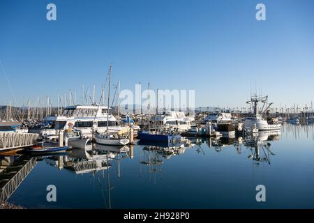 Ventura, USA: 24. Februar 2021: Boote spiegeln sich im ruhigen Hafenwasser im Süden Kaliforniens Stockfoto