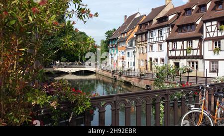 MONSCHAU, DEUTSCHLAND - 08. Jun 2015: Eine Brücke mit geparktem Fahrrad und Pflanzen über einen Fluss in Monschau, Deutschland Stockfoto