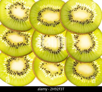 Scheiben einer Kiwi-Frucht in einem regelmäßigen Muster mit Hintergrundbeleuchtung angeordnet Stockfoto