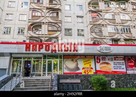 BISCHKEK, KIRGISISTAN - 19. MAI 2017: Betontes Mehrfamilienhaus mit Supermarkt Narodnyi in Bischkek, der Hauptstadt Kirgisistans. Stockfoto