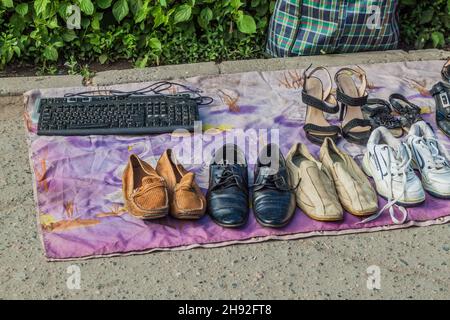 BISCHKEK, KIRGISISTAN - 19. MAI 2017: Schuhe und eine Tastatur zum Verkauf in der Nähe des Osch-Basars in Bischkek, der Hauptstadt Kirgisistans. Stockfoto