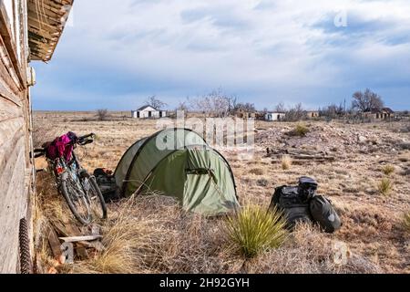 Touring-Radfahrer frei / wild camping mit leichten Kuppelzelt in Yeso, Wüstendorf in De Baca County, New Mexico, USA / USA Stockfoto