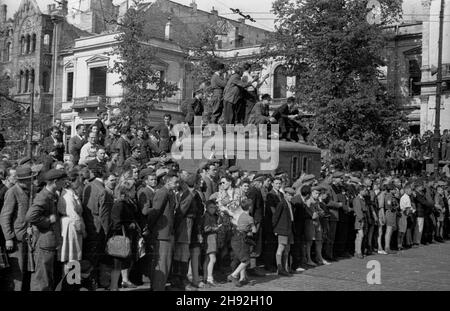 Warschau, 10. Mai 1947. Motorsport. Im Bild: Rennsportfans an der Ecke der Stalin Avenue (heute Ujazdowskie Avenue) und der Pius XI Street (heute Piekna Street). Im Hintergrund der kriegszerstörte Lesser (Rembielinski, Poznanski) Palast. bk/ms PAP Warszawa, 1947-05-10. Wyœcigi motorowe. NZ. kibice na trasie rajdu przy rogu al Stalina (dziœ Al. Ujazdowskie) i ul. Piusa XI (dziœ ul. Piêkna). W tle zniszczony podczas wojny pa³ac Lesserów (Rembieliñskich, Poznañskich). bk/ms PAP Stockfoto