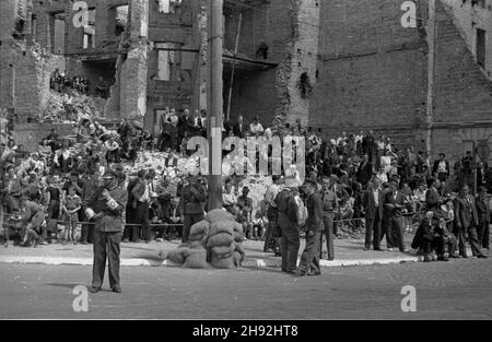 Warszawa, 1947-05-10. Dwudniowe wyœcigi motorowo- motocyklowe na ulicach stolicy. Pierwszy dzieñ rajdu pod has³em 'Sport motorowy odbudowuje stolicê'. NZ. Widzowie na trasie rajdu. W ell zruinowane podczas wojny kamienice. bk/ms PAP Warschau, 10. Mai 1947. Eine 2-tägige Herausforderung für Motorwagen und Motorräder in Warschau. Im Bild: Zuschauer bei der Herausforderung „Motorsports helfen beim Wiederaufbau der Hauptstadt“. In den rückseite kriegszerstörten Häusern. bk/ms PAP Stockfoto