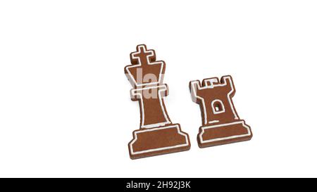3D Wiedergabe von Lebkuchenkeks in Form eines Symbols des Schachkönigs und von Rook-Figuren isoliert auf weißem Hintergrund mit weißer Vereisung Stockfoto