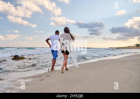 Glückliches Paar, das am Sommertag am Strand zusammen läuft, Rückansicht Stockfoto