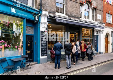 Eine Gruppe junger Menschen, die vor der Caffe in Mayfair, Shepherd Market, London, Großbritannien, stehen. Stockfoto