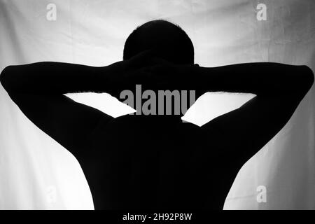 Schwarz-Weiß-Porträt in Silhouette eines Mannes vor weißem Hintergrund. Salvador, Bahia, Brasilien. Stockfoto