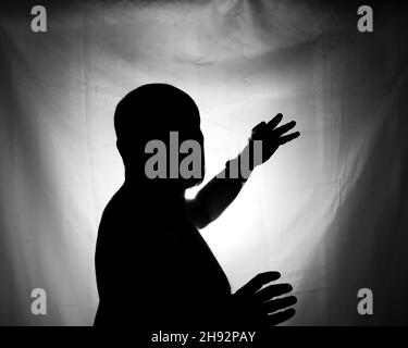 Schwarz-Weiß-Porträt in Silhouette eines Mannes vor weißem Hintergrund. Salvador, Bahia, Brasilien. Stockfoto