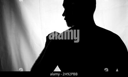 Schwarz-Weiß-Porträt in Silhouette eines Mannes vor weißem Hintergrund. Salvador, Bahia, Brasilien. Stockfoto