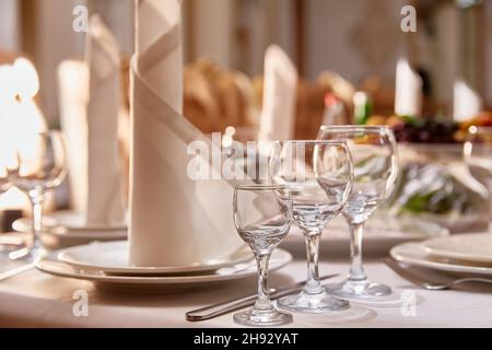 Festlich gedeckter Tisch mit Besteck, schönen Gläsern und einer Serviette im Restaurant. Nahaufnahme. Speicherplatz kopieren Stockfoto