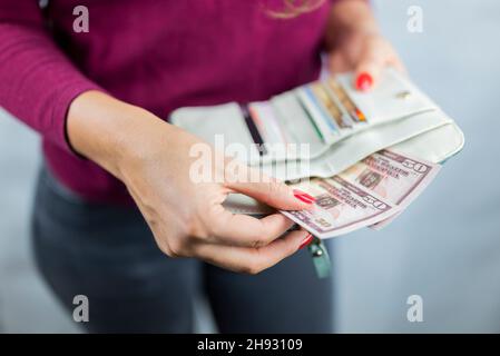 Das Mädchen hält sich in den Händen und zählt die Geldmittel in der Brieftasche Stockfoto