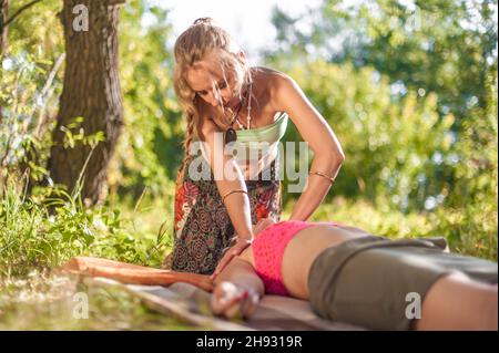 Professionelle Massage Massage gilt ihre Fähigkeiten auf Ihrem Client im Sonnenlicht. Stockfoto