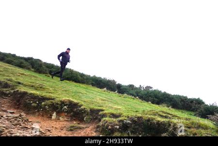 Ein Läufer auf dem Schlangenpfad auf dem Weg nach Hayfield, Derbyshire. Stockfoto