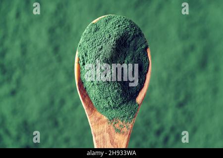 Blaugrünes Spirulina-Algenpulver auf einem Holzlöffel, Draufsicht. Gesunde Nahrungsergänzung. Stockfoto