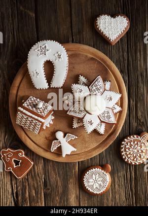 Hausgemachtes Weihnachts-Lebkuchenhaus, Hufeisen, Herz und andere Kekse auf einem Tisch, Draufsicht Stockfoto