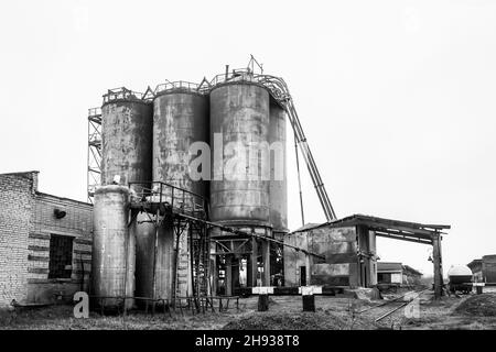 Altes Barrel-Öl für chemische Tanks in einer stillgelegten Industrieanlage anheizen. Stockfoto