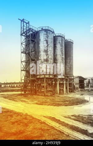 Altes Barrel-Öl für chemische Tanks in einer stillgelegten Industrieanlage anheizen. Stockfoto