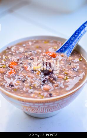 Gesundes chinesisches Getreidebrei in einer Schüssel. Jujube und Goji Berry ganz oben. Isoliert. Heller Hintergrund. Speicherplatz Kopieren Stockfoto