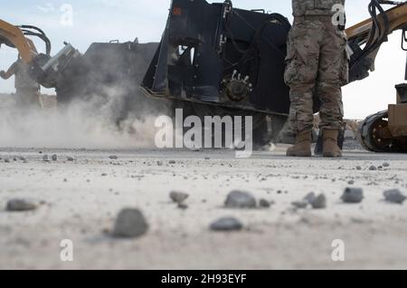 Flugleute, die der Expeditionary Civil Engineer Squadron 386th zugewiesen wurden, schnitten Beton während einer Übung auf dem Luftwaffenstützpunkt Ali Al Salem, Kuwait, 2. Dezember 2021. 386th ECES Airmen reagierten auf einen simulierten Angriff auf einen Flugplatz und führten eine Rapid Airfield Deployment Recovery Mission durch. RADR ist eine Reaktionsmethode, um einen Flugplatz so schnell wie möglich zu aspern, zu reparieren und zu Bergen, um den Betrieb zu ermöglichen. (USA Luftwaffe Foto von Senior Airman Michael S. Murphy) Stockfoto