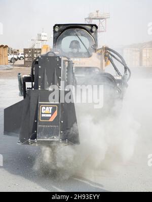 US Air Force Staff Sgt. Michael Lucas, ein Handwerker für die Wartung von Wasser- und Kraftstoffsystemen, der der 386th Expeditionary Civil Engineer Squadron zugewiesen wurde, schneidet Beton mit einem kompakten Traktlader während einer Übung auf dem Ali Al Salem Air Base, Kuwait, am 2. Dezember 2021. 386th ECES Airmen reagierten auf einen simulierten Angriff auf einen Flugplatz und führten eine Rapid Airfield Deployment Recovery Mission durch. RADR ist eine Reaktionsmethode, um einen Flugplatz so schnell wie möglich zu aspern, zu reparieren und zu Bergen, um den Betrieb zu ermöglichen. (USA Luftwaffe Foto von Senior Airman Michael S. Murphy) Stockfoto