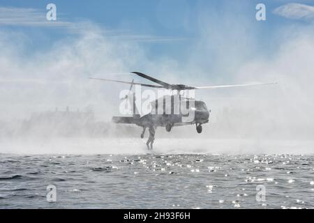 211202-N-KM072-002 KEY WEST, Florida (Dez 2, 2021) Marine Raider der Marine Corps Forces Special Operations Command (MARSOC) K-9 Unit führen zusammen mit dem Such- und Rettungsteam der Naval Air Station Key West während der Mehrzweck-Hundeführer-Ausbildung des Special Operations Command den Hubschrauberabflug von Fleming Key durch. Die Naval Air Station Key West ist die hochmoderne Einrichtung für Kampfflugzeuge aller militärischen Dienste, bietet erstklassigen Pierside-Support für US- und ausländische Marineschiffe und ist das führende Ausbildungszentrum für militärische Einsätze unter und unter Wasser. (USA Entfällt Stockfoto