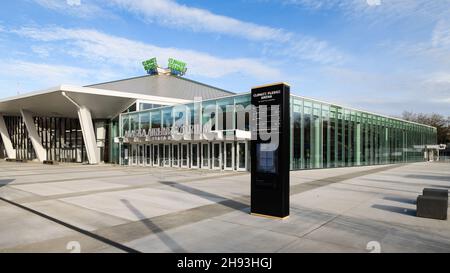 Seattle - 21. November 2021; Blick vom Gehweg auf die Climate Pledge Arena und das Atrium von Alaska Airlines in Seattle mit Glaswänden unter blauem Himmel Stockfoto
