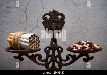 Zigaretten und Medizin in einem ausgewogenen Konzept des ungesunden Somkings Stockfoto