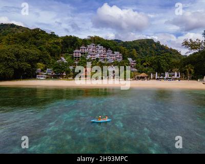 Paar Mann und Frau in Kayak Phuket Thailand. Männer und Frauen Kajakfahren am Strand in Thailand mit blauem Ozean Stockfoto