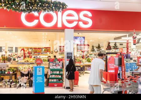 Während der Covid 19 Pandemie Coles Supermarkt in Australien verlangt Kunden, Check-in und tragen Gesichtsmasken, wie dieser Mann tut Stockfoto