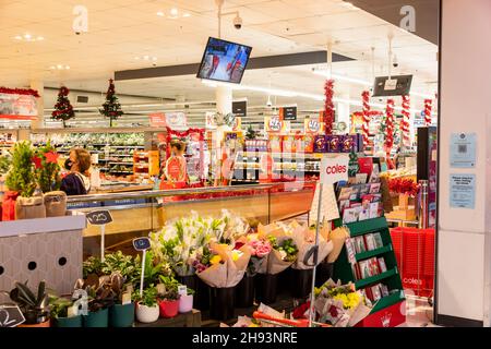 Coles australische Supermarktfrau mit Gesichtsmask wegen der 19. Weihnachtseinkäufe im Geschäft, Sydney, Australien Stockfoto