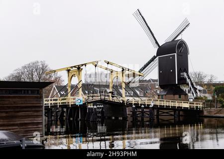 Die Rembrandtbrug (Rembrandtbrücke) und Molen de Put Windmühle auf dem Galgewater des Rheins in Leiden, Niederlande. Stockfoto