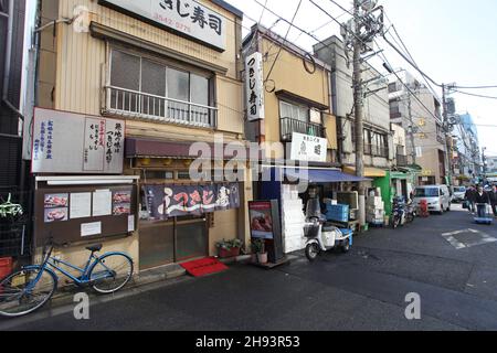 Seitenstraßen in der Nähe des Tsukiji-Fischmarktes in Chuo ward, Tokio, mit Restaurants und Geschäften, die Meeresfrüchte verkaufen. Stockfoto