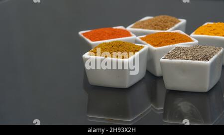 Auswahl an Pulvergewürzen in Schüsseln. Selektiver Fokus. Chili, Kurkuma, Pfeffer, Currpulver usw. Stockfoto