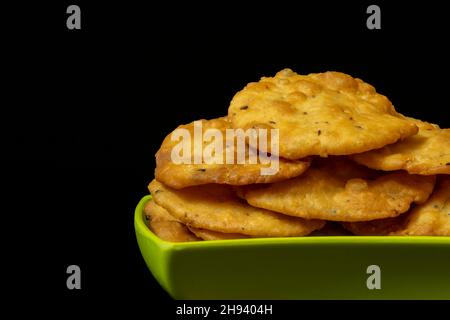 Farsi Puri in Square Green Bowl, Copy Space auf der linken Seite, Close-Up, isoliert auf schwarzem Hintergrund, Gujarati und indische Snacks, White Flour (Maida), Nam Stockfoto