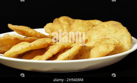 Nahaufnahme Farsi Puri In White Plate, Gujarati Und Indische Snacks, Isoliert Auf Schwarzem Hintergrund, Namkeen, Copy Space Stockfoto