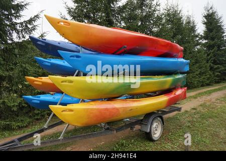 Kunststoff-Massenprodukte Kajaks in verschiedenen Farben auf der Strecke. Stockfoto