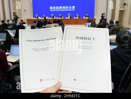 Peking, China. 4th Dez 2021. Das Foto zeigt die chinesische und englische Ausgabe des White Papers mit dem Titel „China: Demokratie, die funktioniert“ auf einer Pressekonferenz, die vom Informationsbüro des Staatsrats in Peking, der Hauptstadt Chinas, am 4. Dezember 2021 abgehalten wurde. Quelle: Li He/Xinhua/Alamy Live News Stockfoto