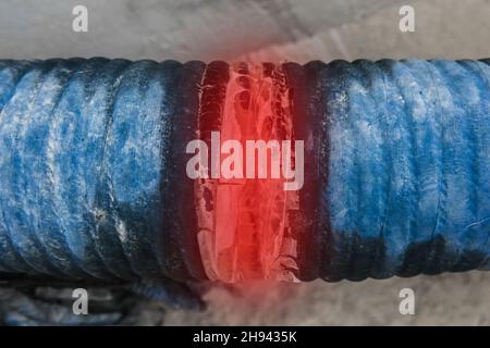 Gebrochenes Rohr einer undichten Leitung der Heizleitung beschädigte altes Industrierohr. Stockfoto