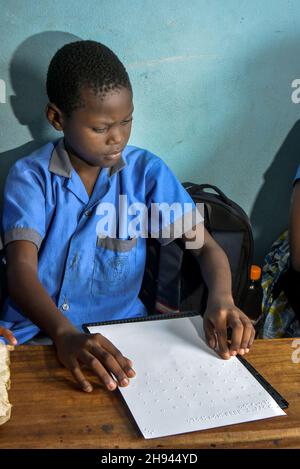 (211204) -- YAOUNDE, 4. Dezember 2021 (Xinhua) -- Ein blinder Junge lernt Brailleschrift im Rehabilitationsklub für blinde Jugendliche in Yaounde, Kamerun, 29. November 2021. Menschen mit Behinderungen in Kamerun folgen verschiedenen Ausbildungs- und Sozialprogrammen in Institutionen wie der Fachschule für hörgeschädigte Kinder und dem Rehabilitationsklub für blinde Jugendliche, die ihnen helfen, sich wieder in die Gemeinschaft zu integrieren. Es gibt schätzungsweise 3,5 Millionen Menschen mit Behinderungen in Kamerun, und die Regierung war entschlossen, ihr Wohlergehen in der Gesellschaft zu gewährleisten, so der Sozialminister des Landes, Pau Stockfoto