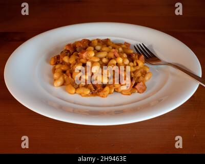 Bean Gulasch oder Wiener Bohnengulasch, ein Wiener Eintopf aus Wien, Österreich auf einem weißen Teller mit Gabel Stockfoto