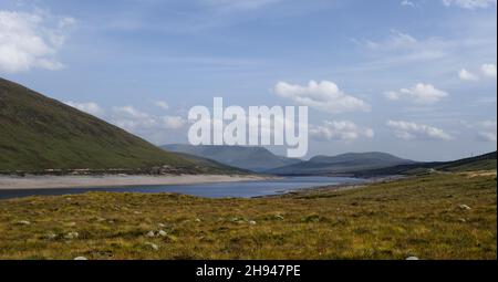 Blick über den Glascarnoch Dam und Loch Glascarnoch in Richtung Ben Wyvis und an Cabar, Scottish Highlands, Schottland Stockfoto