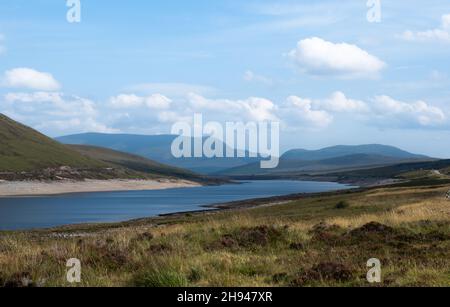 Blick über den Glascarnoch Dam und Loch Glascarnoch in Richtung Ben Wyvis und an Cabar, Scottish Highlands, Schottland Stockfoto