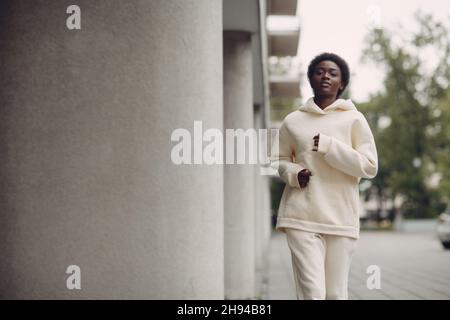 Afroamerikanische Läuferin Frau im Hoodie beim Joggen im Freien. Stockfoto