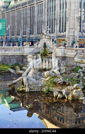 Triton-Brunnen an der Königsallee in der Düsseldorfer Innenstadt. Das historische Gebäude im Hintergrund ist das Kaufhaus Galerie Kaufhof. Stockfoto