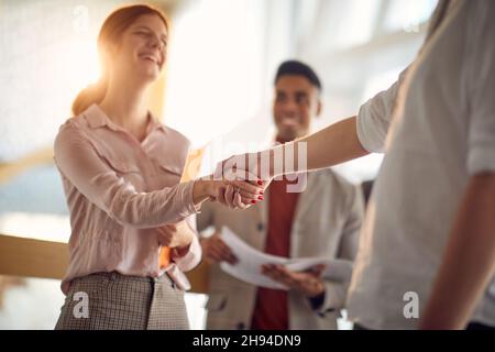 Eine junge Geschäftsfrau freut sich, dass sie ihre Kollegen in einer freundlichen Atmosphäre auf dem Flur getroffen hat. Unternehmen, Mitarbeiter, Unternehmen Stockfoto