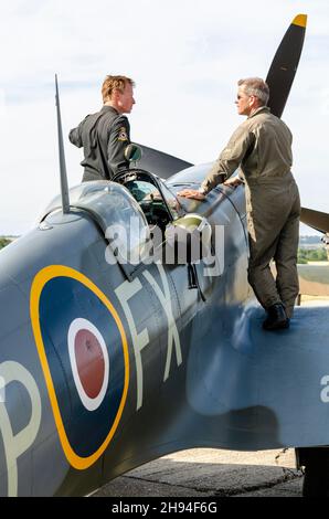 Die Piloten Anthony Parkinson und John Dodd auf dem Spitfire-Kampfflugzeug TD314 aus dem zweiten Weltkrieg, bevor sie auf der Airshow in Headcorn, Kent, Großbritannien, gezeigt wurden. Stockfoto